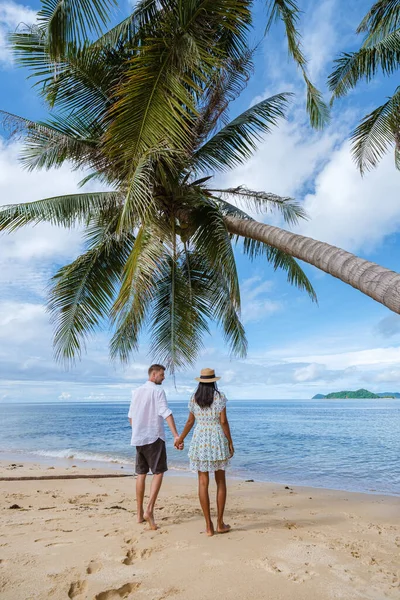 タイの島にヤシの木があるビーチでリラックスしたアジアの女性と白人男性 ビーチのヤシの木と白い砂 — ストック写真