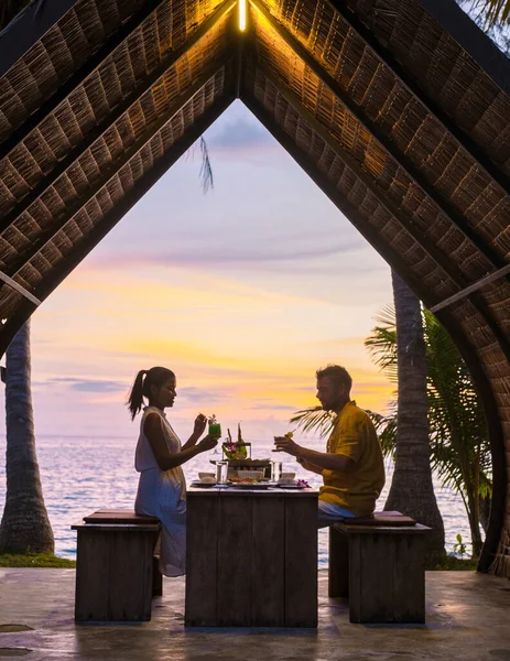 Romantic dinner on the beach with Thai food during sunset on the Island of Koh Mak Thailand. Couple men and women having romantic dinner on the beach