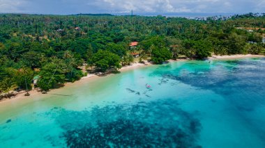 Tayland okyanusunda kano süren çift, mavi okyanusta kano süren erkek ve kadınlar ve Koh Mak adasında palmiye ağaçları olan beyaz plaj.