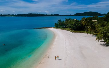 Koh Kham Trat Tayland 'ın insansız hava aracı görüntüsü, Koh Mak Tayland yakınlarındaki tropik adanın havadan görüntüsü. Beyaz kumlu sahil, palmiye ağaçları ve okyanusta büyük siyah kaya taşları.
