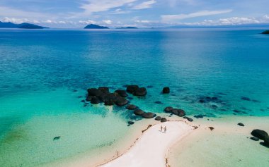 Koh Kham Trat Tayland 'ın insansız hava aracı görüntüsü, Koh Mak Tayland yakınlarındaki tropik adanın havadan görüntüsü. Beyaz kumlu sahil, palmiye ağaçları ve okyanusta büyük siyah kaya taşları.