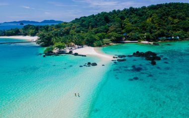 Koh Kham Trat Tayland 'ın insansız hava aracı görüntüsü, Koh Mak Tayland yakınlarındaki tropik adanın havadan görüntüsü. Beyaz kumlu sahil, palmiye ağaçları ve okyanusta büyük siyah kaya taşları.