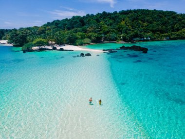 Koh Kham Trat Tayland 'ın insansız hava aracı görüntüsü, Koh Mak Tayland yakınlarındaki tropik adanın havadan görüntüsü. Beyaz kumlu sahil, palmiye ağaçları ve okyanusta büyük siyah kaya taşları.