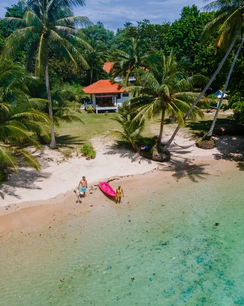 在泰国海洋中的皮划艇上的一对夫妇 在蓝色的海洋中的皮划艇上的男男女女 以及在高茂岛上拥有棕榈树的白色海滩上的男女 — 图库照片