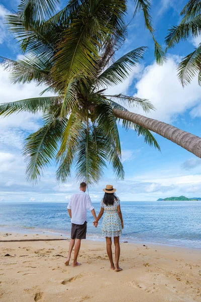 在泰国的一个热带岛屿上 一对男女在悬挂的棕榈树下散步度假 热带岛屿上绿松石色的水和棕榈树 无人驾驶飞机俯瞰 — 图库照片