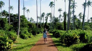 Koh Mak Tayland adasında palmiye ağaçları arasında yürüyen Asyalı kadınlar. Koh Mak adasında dev palmiye ağaçları