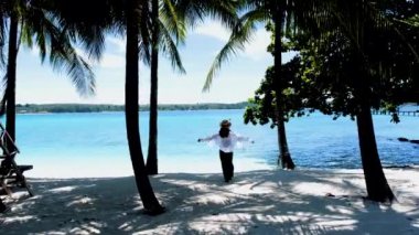 Koh Kham Trat Tayland 'da beyaz bir tropik plajda yürüyen Asyalı kadınlar.