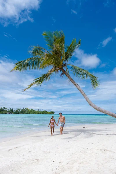 해변에 나무가 아시아 여인들 원주민 남자들이 해변에 야자나무를 매달고 — 스톡 사진
