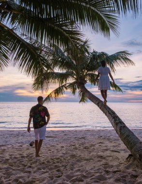Tropikal bir plajda gün batımını izleyen çift, Koh Kood veya Koh Kut Tayland. 