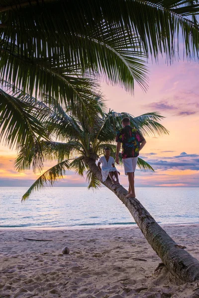 Чоловіки Жінки Відпочивають Пальмі Тропічному Пляжі Спостерігаючи Захід Сонця Під — стокове фото