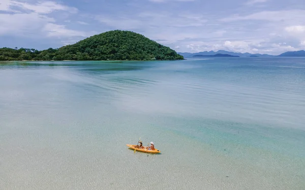 2人の中年男性と女性が タイのコマック島の熱帯の海でカヤックを漕いでいます 青い海と白い砂浜にヤシの木があるカヤックの男と女 — ストック写真