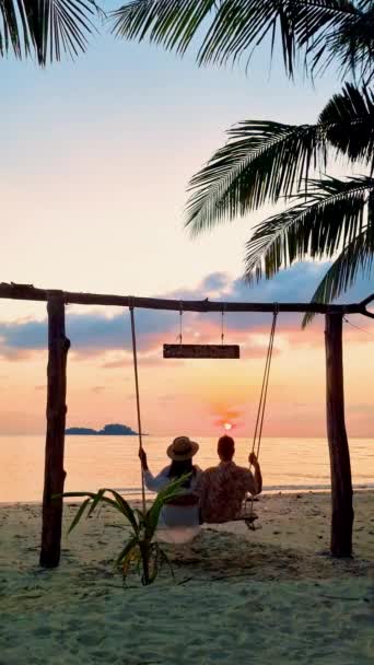 Par Hombres Mujeres Viendo Puesta Sol Playa Desde Columpio Tailandia — Vídeos de Stock