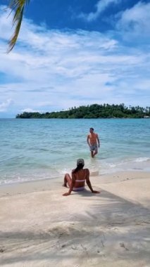 Koh Kood Tayland adasında tatilde olan birkaç erkek ve kadın. Erkekler ve kadınlar okyanusun kenarında dinleniyor.