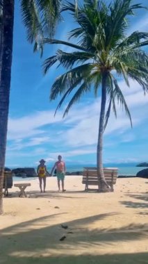 Koh Kham Trat Tayland, Koh Mak Tayland yakınlarındaki tropik adanın havadan görünüşü. Yüzme kıyafetleriyle beyaz bir tropikal plajda yürüyen bir çift kadın ve erkek.