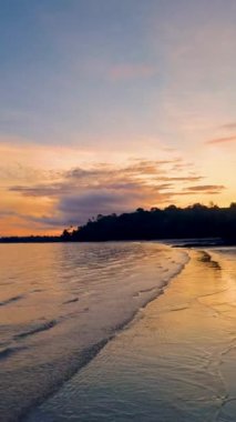 Tropikal Koh Mak Tayland adasında bir sahilde gün batımı. Sahilde gün batımında turuncu ve pembe renkler