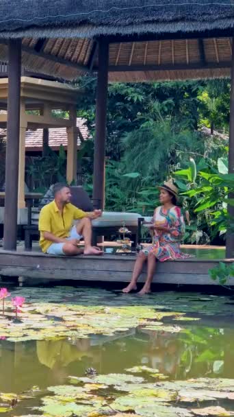 下午茶在一个池塘里 茶在泰国的一个热带花园里 一对夫妇在热带花园里喝着高茶 — 图库视频影像