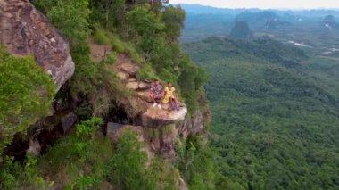Dragon crest rock in the jungle of Krabi Thailand, couple men and woman looking out over the jungle. Dragon Crest or Khuan Sai at Khao Ngon Nak Nature Trail in Krabi