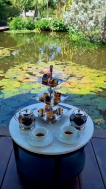 Bir su birikintisinde ikindi çayı, Tayland 'da tropikal bir bahçede çay.. 