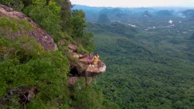 Dragon crest rock in the jungle of Krabi Thailand, couple men and woman looking out over the jungle. Dragon Crest or Khuan Sai at Khao Ngon Nak Nature Trail in Krabi