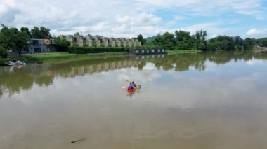 A couple of men and women in kayak on the River Kwai in Thailand. men and women peddling in a kayak on the river in Thailand