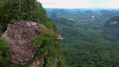 Dragon crest rock in the jungle of Krabi Thailand, couple men and woman looking out over the jungle. Dragon Crest or Khuan Sai at Khao Ngon Nak Nature Trail in Krabi