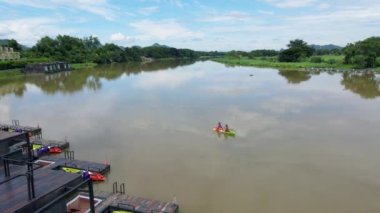 A couple of men and women in kayak on the River Kwai in Thailand. men and women peddling in a kayak on the river in Thailand