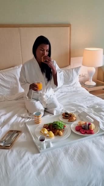 亚洲女人在床上吃早餐 卧室里的女人早上吃早餐 咖啡和水果 — 图库视频影像
