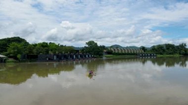 A couple of men and women in kayak on the River Kwai in Thailand. men and women peddling in a kayak on the river in Thailand