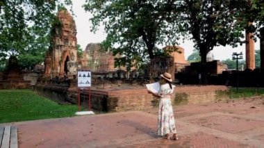 Ayutthaya, Thailand at Wat Mahathat, women with a hat and tourist map visiting Ayyuthaya Thailand. Tourist with map in Thailand