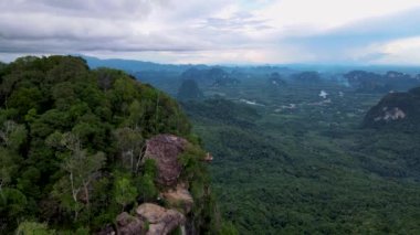 Dragon crest rock in the jungle of Krabi Thailand, couple men and woman looking out over the jungle. Dragon Crest or Khuan Sai at Khao Ngon Nak Nature Trail in Krabi