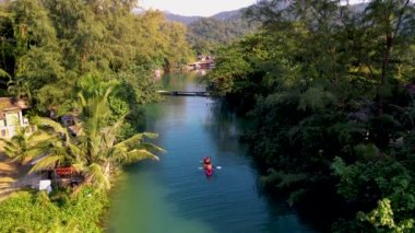 Öğleden sonra kanoyla gezen birkaç erkek ve kadın tropik bir ada olan Koh Chang Tayland 'da kayak yapan insanlar.. 