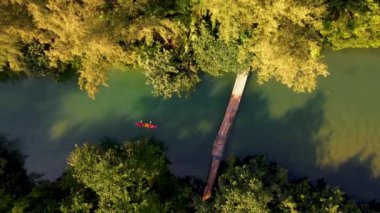 Gün batımında kanoyla gezen birkaç erkek ve kadın tropikal bir ada olan Koh Chang Tayland 'da kayak yapan insanlar.. 
