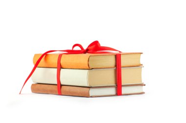 kitap yığını üzerinde beyaz bir backg izole kırmızı kurdele ile bağlanmış