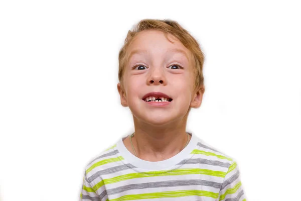 その少年は歯のない笑顔を見せる 子供は上の歯を失い 白い背景に閉じ込められています ストック写真