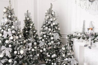 Beyaz süslemeleri ve beyaz şöminesi olan bir Noel ağacı. Beyaz gümüş renkli dekor, Noel ve Yeni Yıl için açık renk.