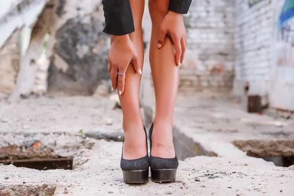 Duvarda siyah ayakkabılı kadın bacakları