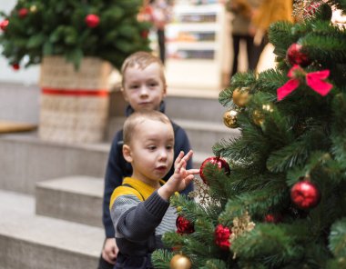 Noel ağacı olan bebek. Çocuk bir Noel ağacı ve Noel oyuncakları görünce şaşırdı.