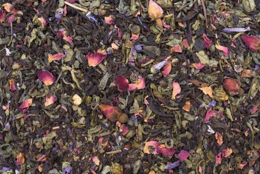 Kuru çay yakın plan. Büyük yapraklı Seylan çayı ve yeşil çay karışımı Sencha 1001 Gece üzümler, papaya küpleri, mallow çiçekleri, güller ve doğal yağlarla tatlandırılmış takvim.