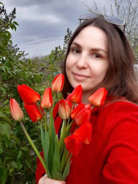 Elinde bir buket kırmızı lale tutan genç kadın, selfie çeken kadın.