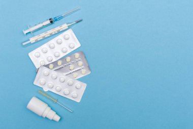 haplar ve tabletler termometre, mavi arkaplan üzerinde şırınga metin yeri ve yeri.