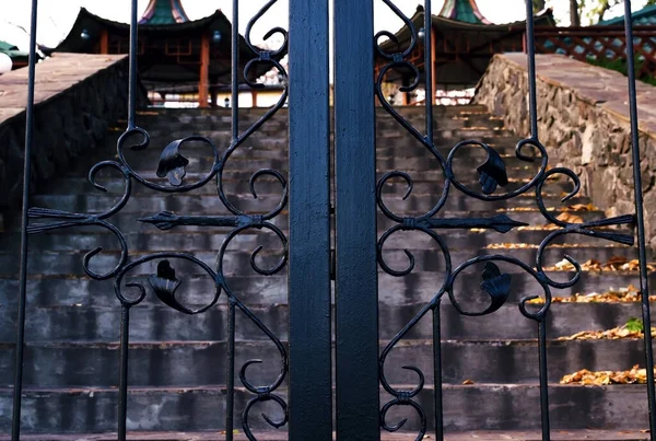 Parkta eski çitler var. Arka planda bir yol var..