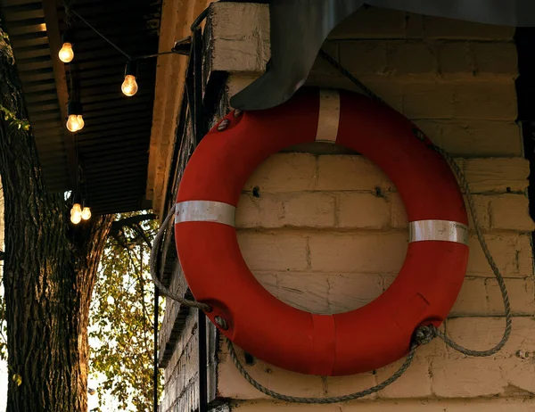 Life buoy on the wall at the pier. The building is decorated with vintage light bulbs. Royalty Free Stock Photos