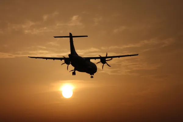 Flugzeug landet bei Sonnenuntergang — Stockfoto