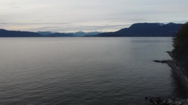 Kanada 'nın arka planında kar zirvesi olan sakin suların üzerinden uç