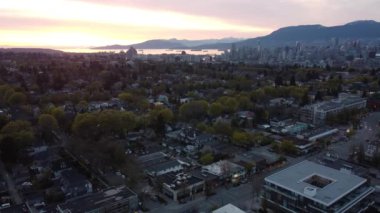 Vancouver 'da gün batımında şehir merkezinde geniş bir caddenin üzerinden uç.