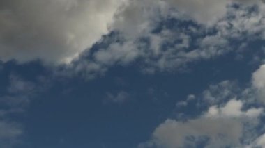 Açık gri bulutlar, güneşli bir günde mavi gökyüzünü kaplıyor.