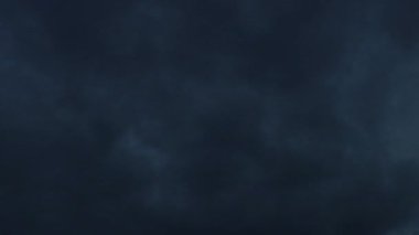 Gri bulutlar mavi bir gökyüzünde zaman lambası ve gecenin karanlığında kayboluyor.