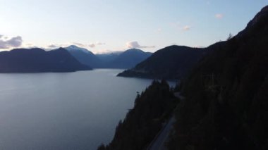 Akşamları dağ ve nehir kenarlarında yol manzarası var.
