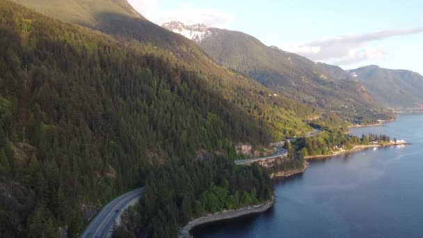 飞越蜿蜒曲折的道路和靠近加拿大蓝水的翡翠森林山脉 — 图库视频影像