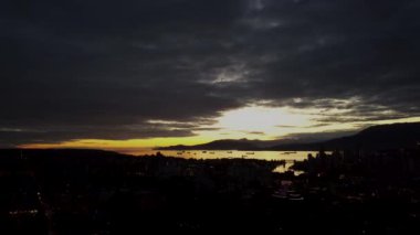 Aerial Vancouver in evening with view on a creek with cargo ships and mountains